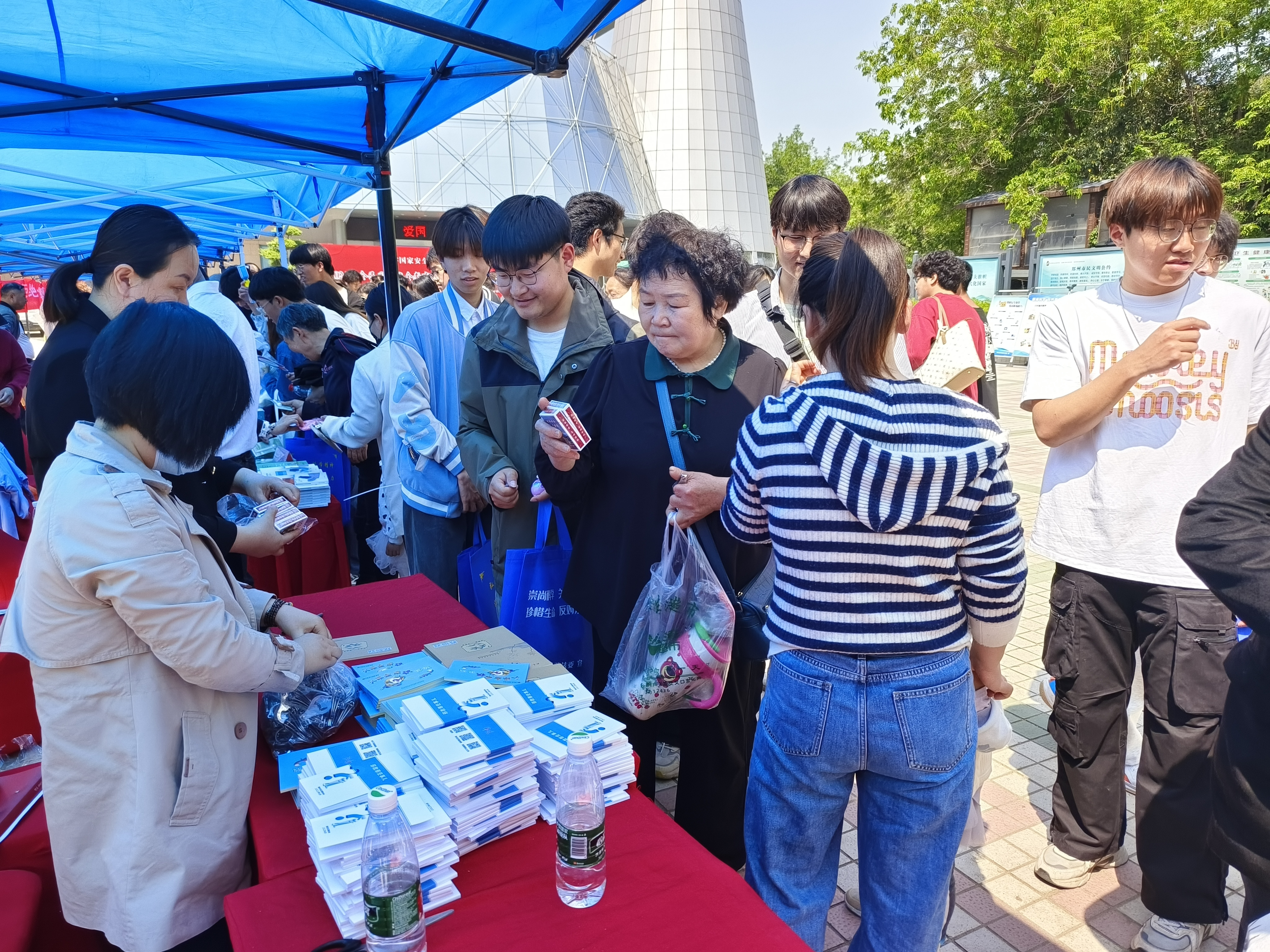 郑州市反邪教协会志愿者向群众发放反邪教图书、扑克、遮阳伞等宣传品 (1).jpg
