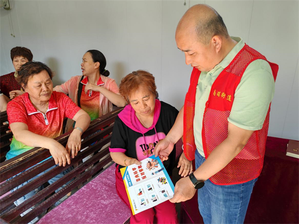 志愿者向信教群众现场讲解宣传单页内容图片2.jpg
